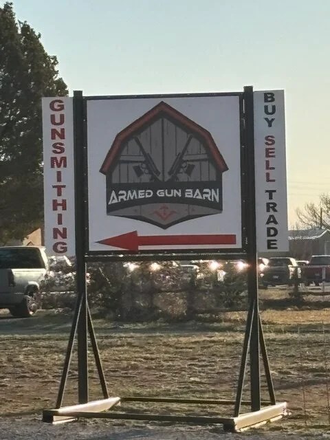 Armed Gun Barn sign at the road with an arrow pointing to the private drive
